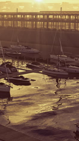 sunset over a tranquil marina with boats docked and shimmering water