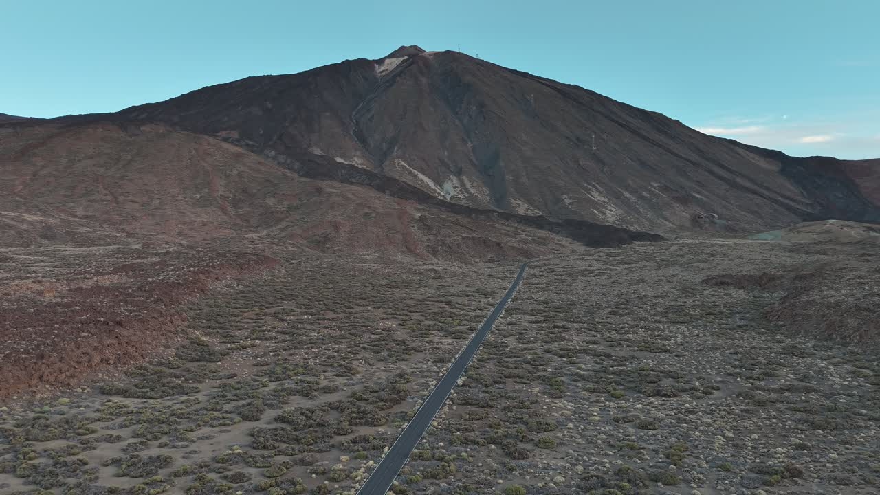 Aerial fly at rural road to the volcano mountain through a barren landscape, Tenerife, Canary Islands, Spain