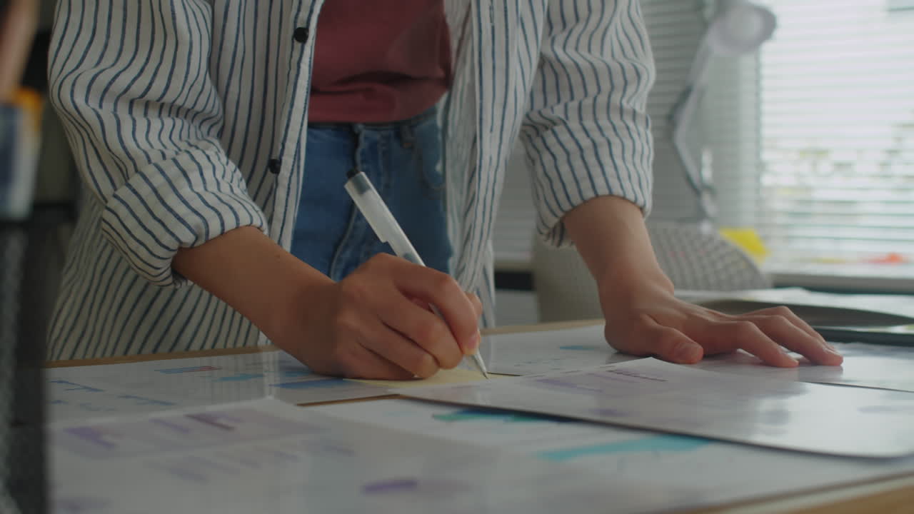 Female Employee Making Notes on Paper Working on Project