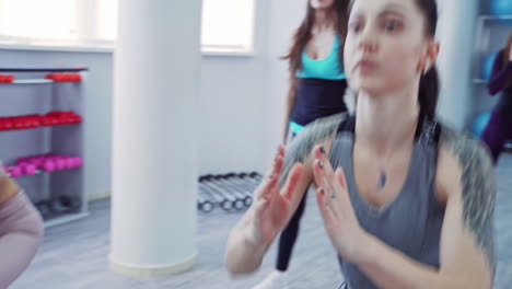 Group of training girls in the gym. Group of young sporty attractive woman practicing yoga lesson with instructor