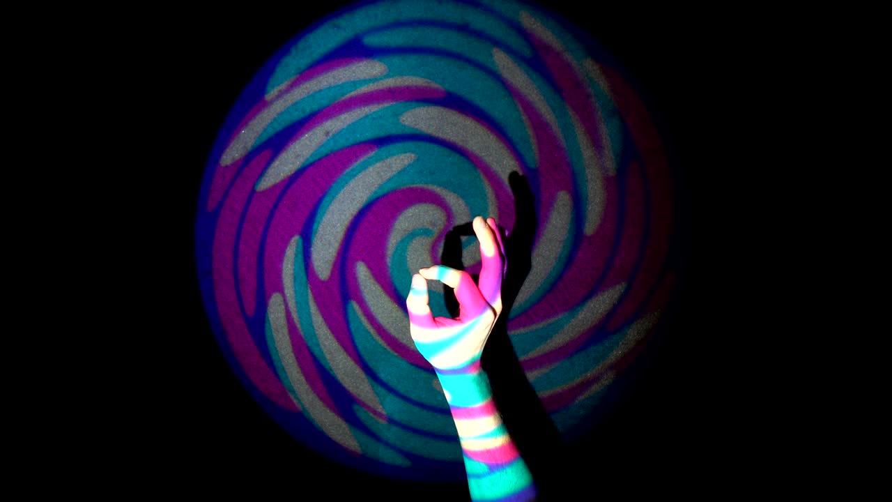 la mano umana mostra il segno ok sullo sfondo di un anello colorato attraverso il tunnel