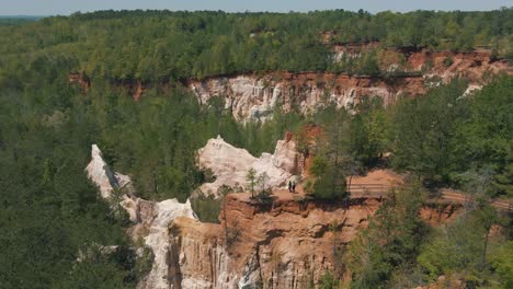 incredible drone footage of people on a cliff looking out at the canyon below