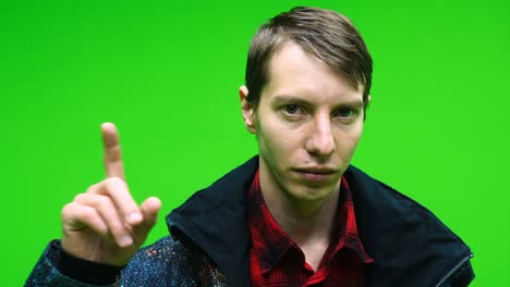 young man disapproving with no hand sign make negation finger gesture on green screen background.