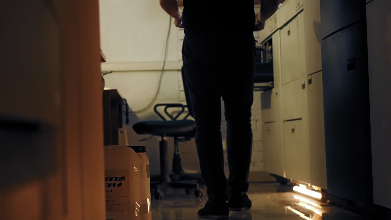 hombre cargando papel en una gran impresora