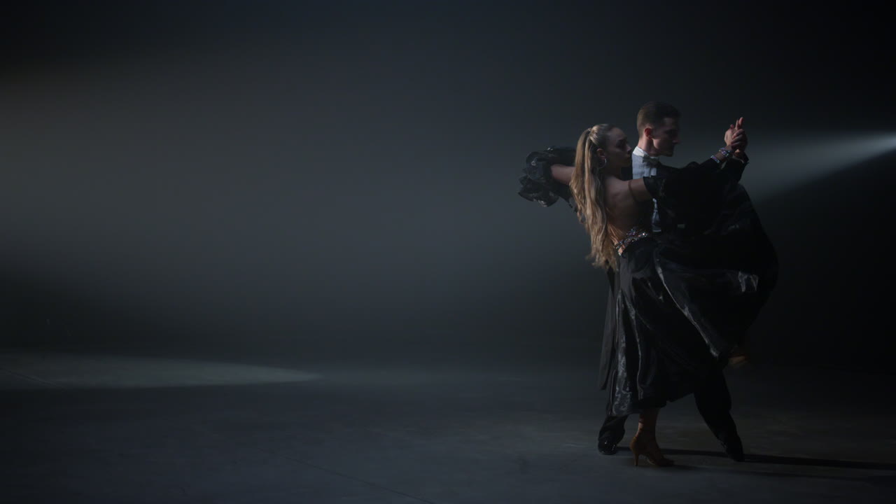 una pareja de baile de salón actuando en el interior. bailarines apasionados moviéndose en el escenario.