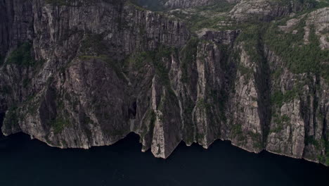 una amplia toma aérea, empujando en los acantilados debajo de preikestolen, por lysefjord en noruega
