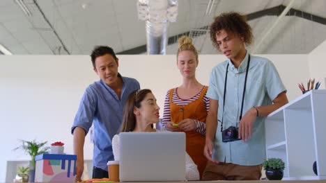 caucasian businesswoman working on his laptop is interacting with others business people in a office
