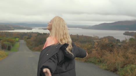 woman feeling nature spinning in front of lake view