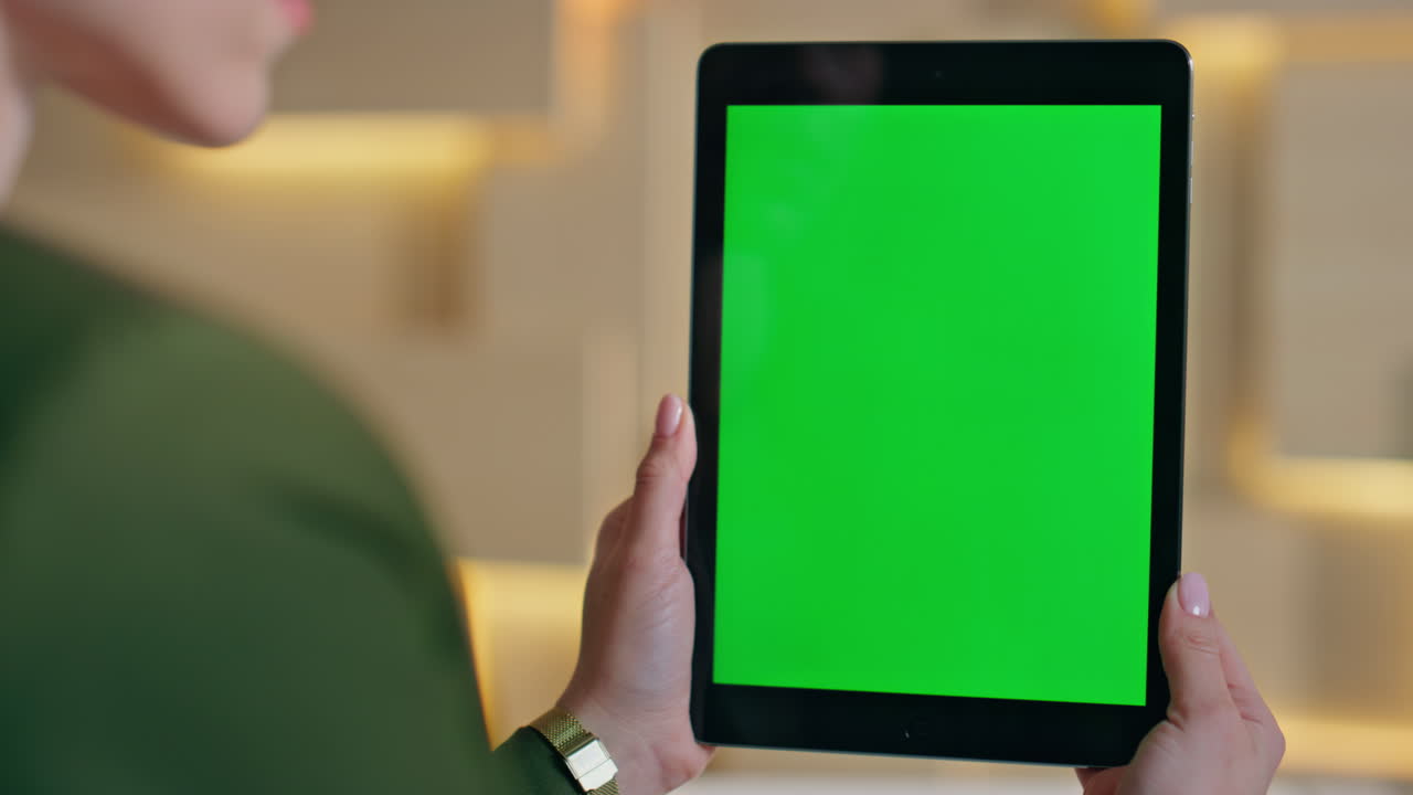 Online consultant browsing green screen tablet at remote workplace close up.