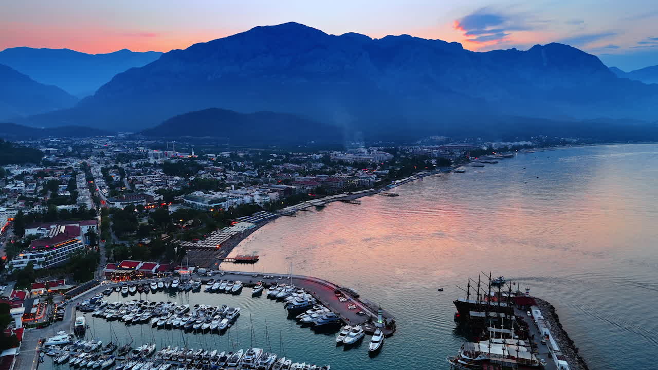 Developed touristic sea resort at the time of dusk. Drone flight over the beach and yacht club in Kemer, Turkey