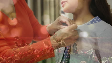 animation of christmas decorations over biracial mother with daughter talking