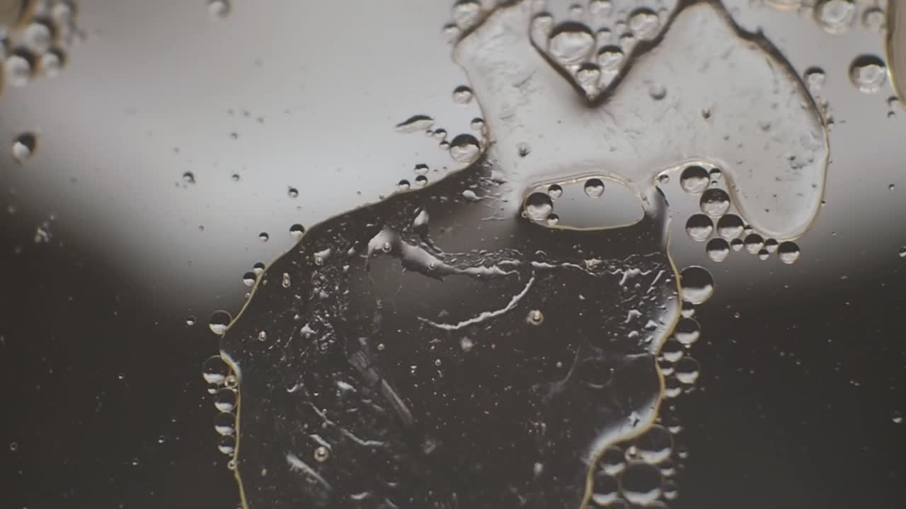 gotas de aceite y formas abstractas flotando en el agua sobre la calma subterránea en colores monocromáticos