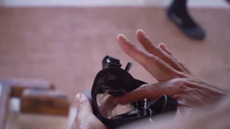 la mano de un hombre se frota con saliva una máscara para evitar que se empañe durante la inmersión