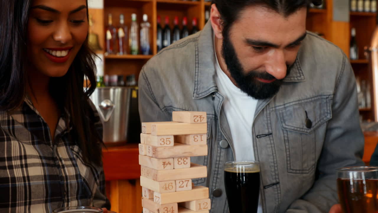 grupo de demonios jugando a la jenga mientras toman cerveza 4k