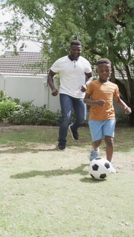 vertical video: african american father and son are playing soccer