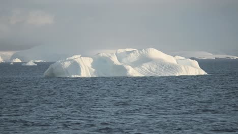 Kleiner-Eisberg-In-Der-Antarktis-Mit-Bergkette-Und-Gletscher-Im-Hintergrund