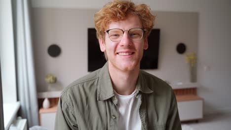 headshot portrait of positive smiling young ginger british man