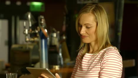 mujer usando su tableta en la barra