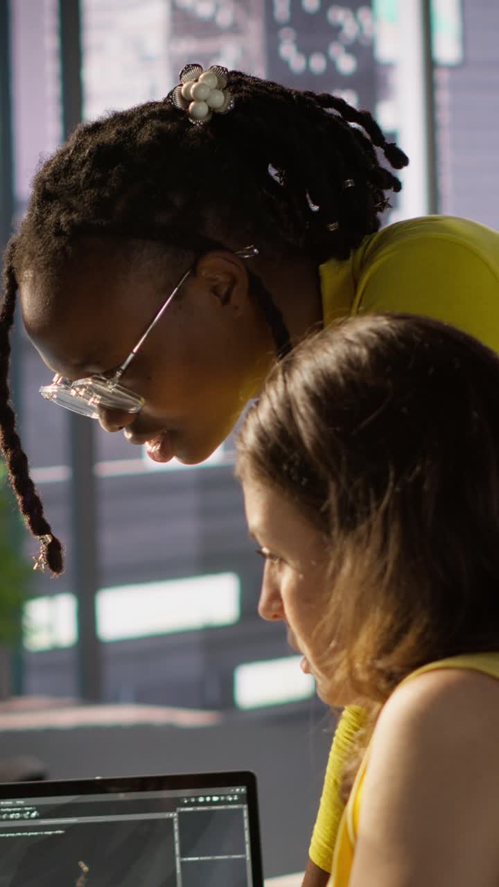 Vertical video Woman and colleague monitoring AI company systems using computer
