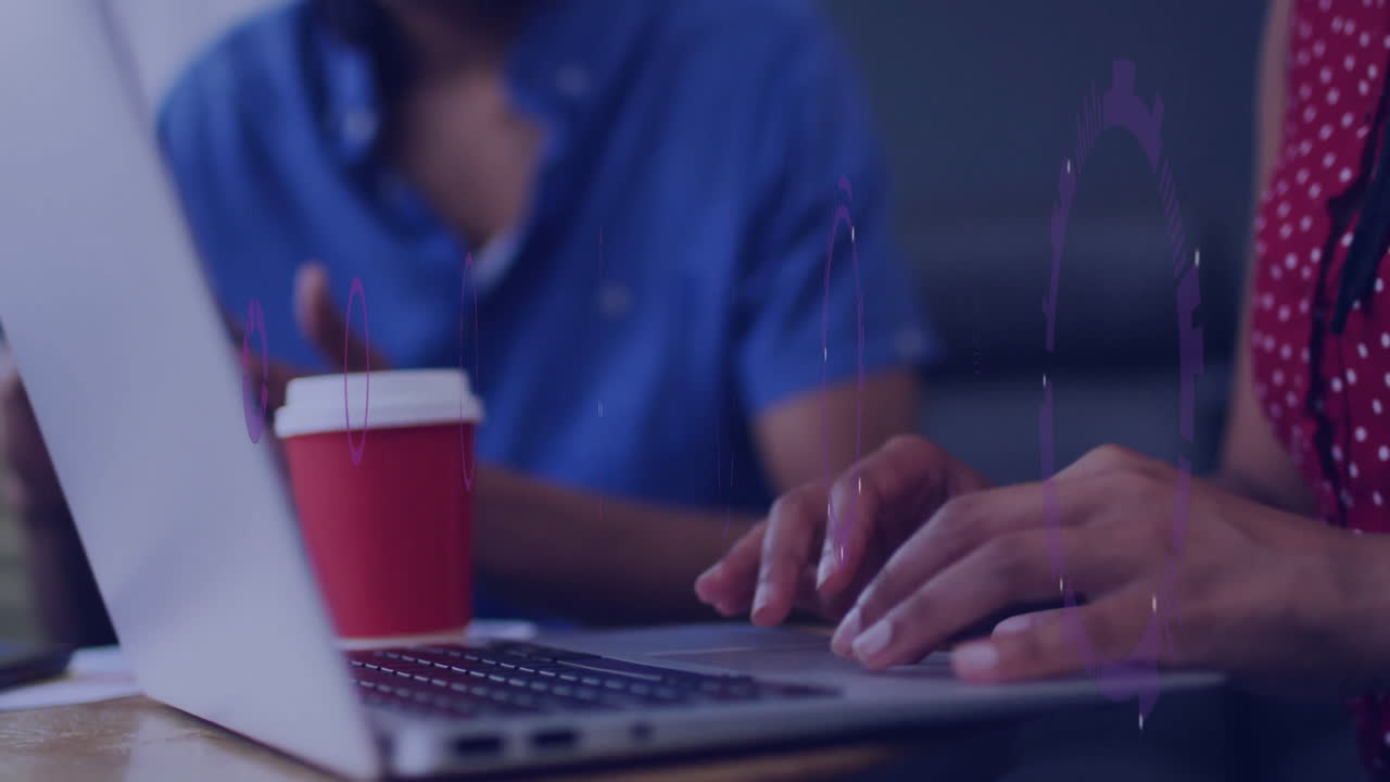 Typing on laptop with coffee, animation of data visualization overlaying screen