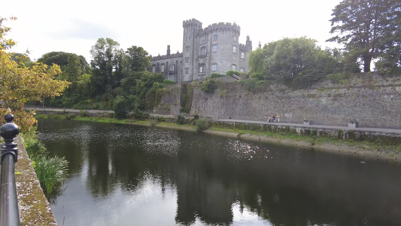 Inquadratura panoramica verso destra del Castello di Kilkenny dal fiume Nore in una giornata di sole in Irlanda