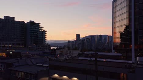 Low-Flying-Aerial-Drone-Shot-Of-Downtown-Vancouver-With-Skyscrapers-Reflection-And-Vibrant-Red-Skies,-British-Columbia,-Canada