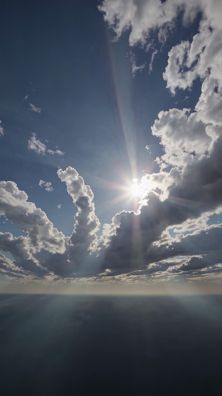Aerial video captures dramatic clouds and sunburst over the horizon, shot from a high angle