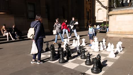 people playing giant chess outside library