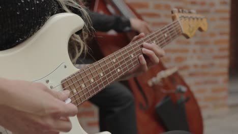 guitarist playing electric guitar with music band, double bass player in background