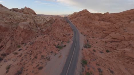 Fast-fpv-aerial-forward-along-Valley-of-Fire-road,-red-sandstone-formations,-Mojave-Desert,-Nevada