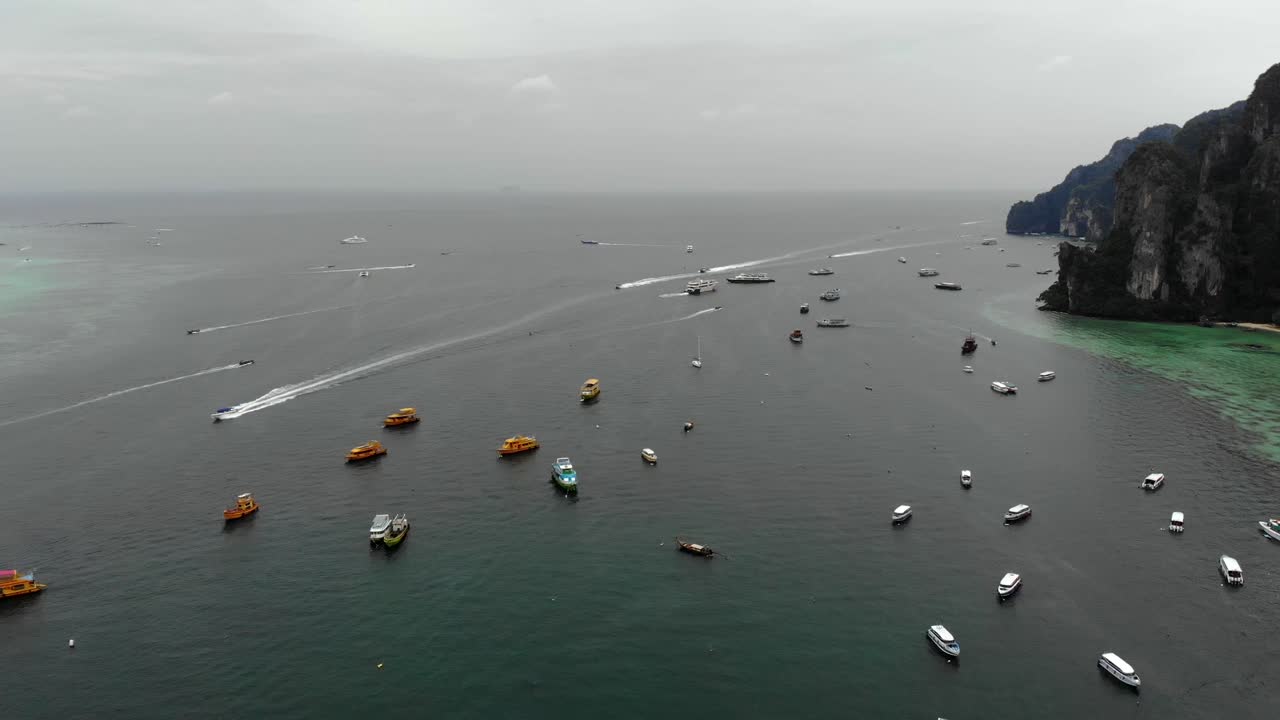 4개의 정렬된 보트가 태국 푸켓 피피 섬의 보트 사이에서 해안 쪽으로 운전하고 있습니다.