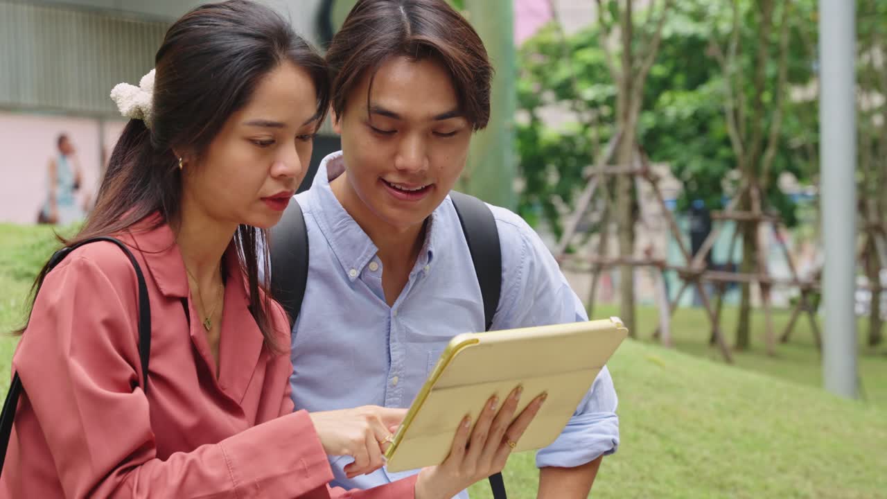 Friends looking at a tablet outdoors