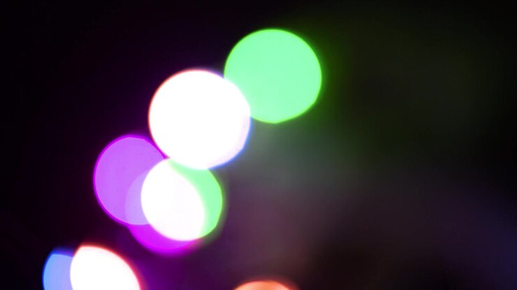 Luci bokeh colorate in movimento su sfondo scuro