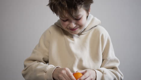 boy peeling an orange