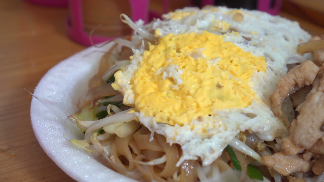 disparo giratorio de fideos pad thai, famosa comida callejera en tailandia