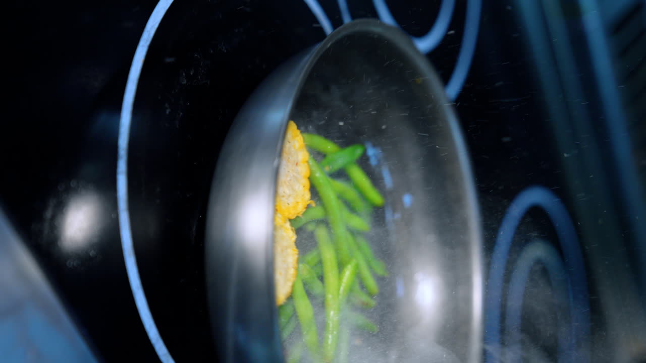 Frying maize and green beans on the frying-pan. Preparing the side dish for the meat course. Vertical screen. Close up.