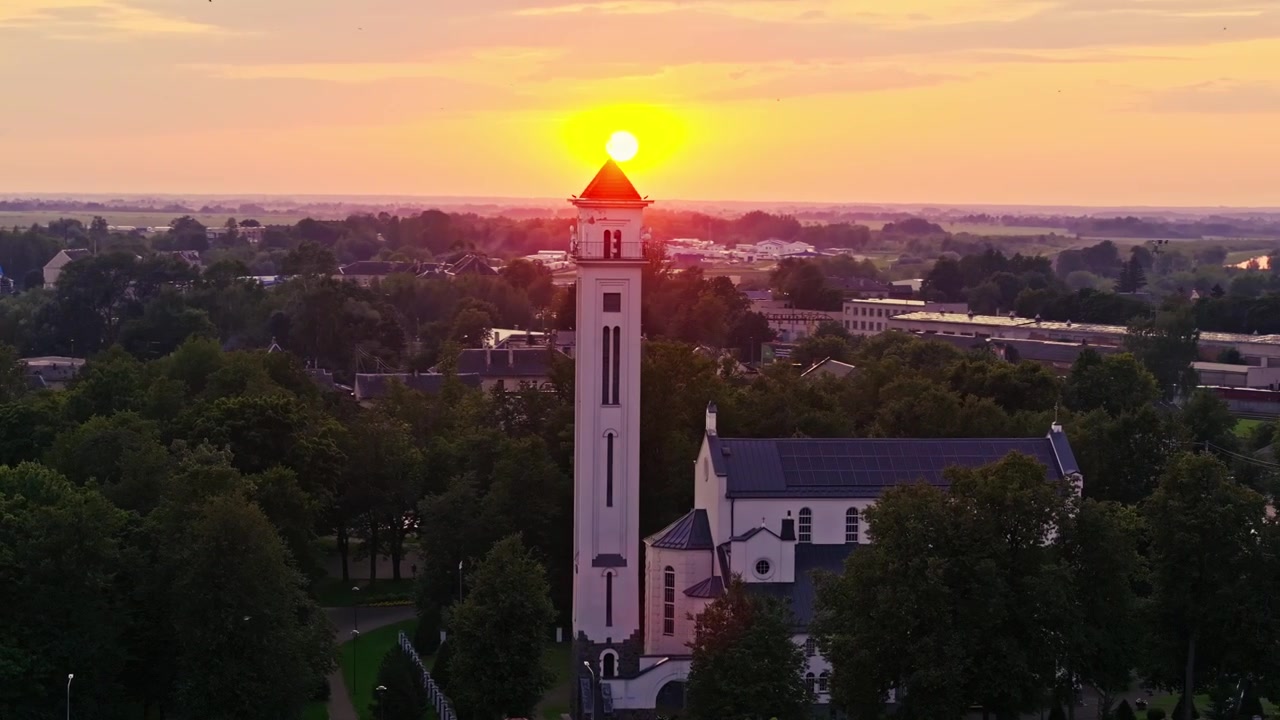 Drone kredser om Kybartai kirke over geopolitisk grænseby i solnedgangens skær