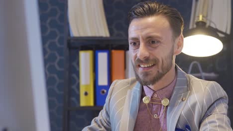 retrato de un elegante hombre de negocios trabajando en una oficina moderna mientras usa su computadora.
