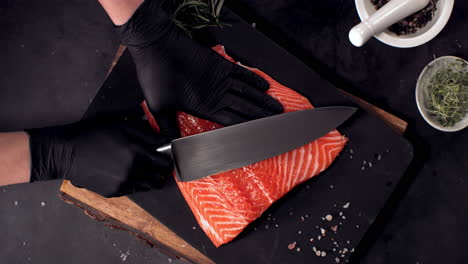 super slow motion overhead view of cutting fresh uncooked salmon fillet lying on table. shot with high speed camera, 420 fps