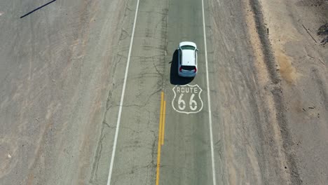 vista aérea de un coche conduciendo sobre la ruta 66 escudo en la carretera en ludlow california