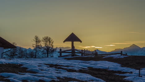 hermoso amanecer en la cima de la montaña nevada y la cruz de la cumbre durante el día de invierno, lapso de tiempo