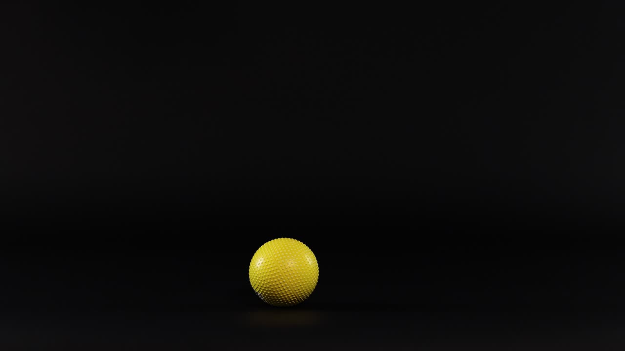 A yellow ball bounces against a dark background