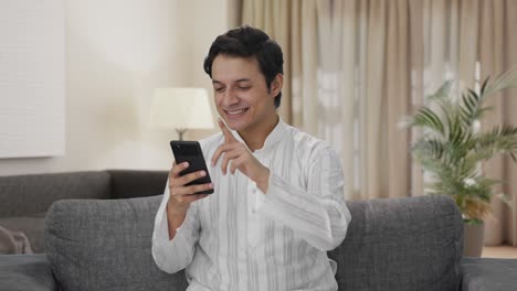 Happy-Indian-man-scrolling-phone