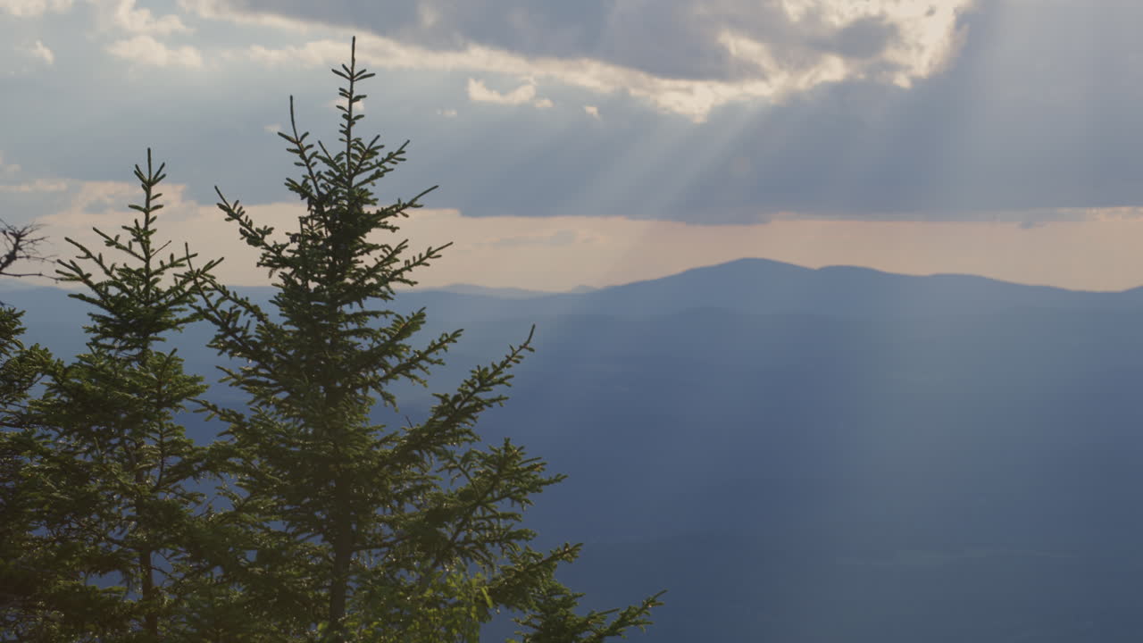 una vista del paisaje de la cima de la montaña al atardecer con los rayos de luz de dios bajando en vermont