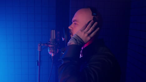 man singing into a microphone in a recording studio