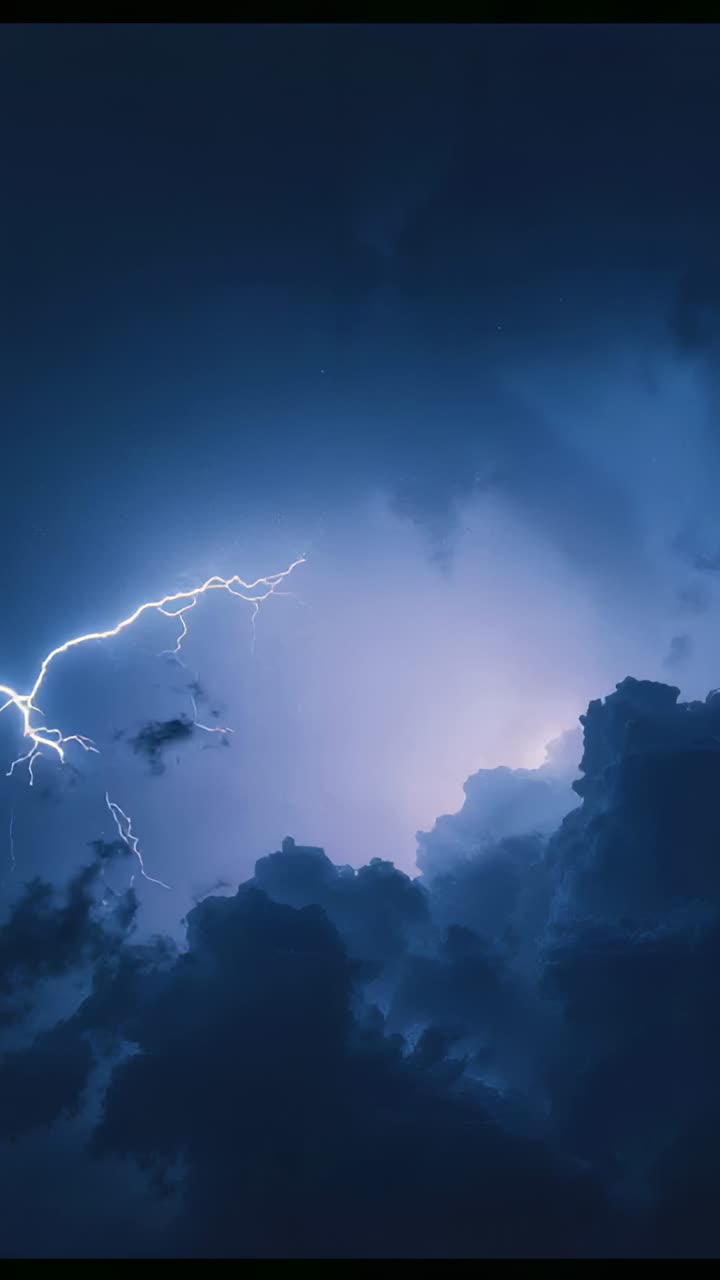 Vertical video: Lightning flashing, storm clouds pulsing and revealing night sky during storm
