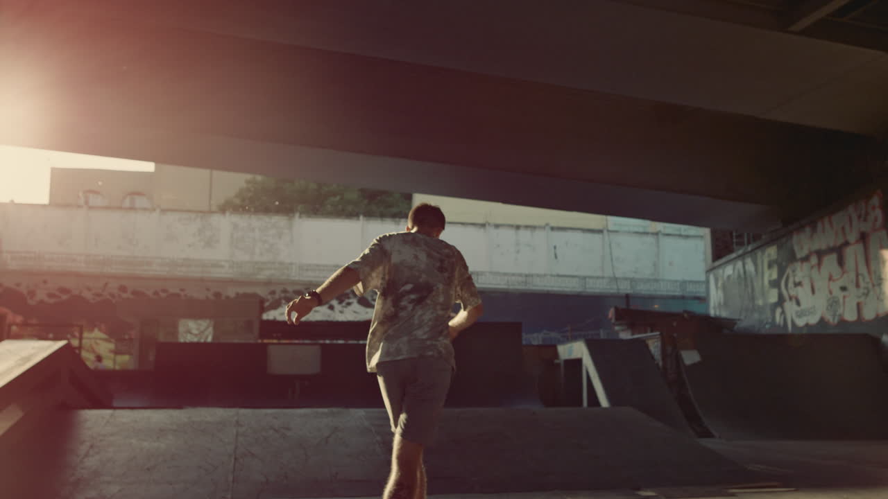 Young hipster skating roller skates at skate park with graffiti on wall.