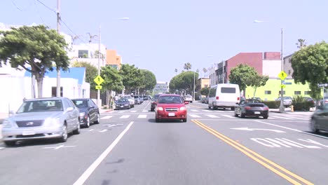 a car travels along a street in venice california as seen through the rear window