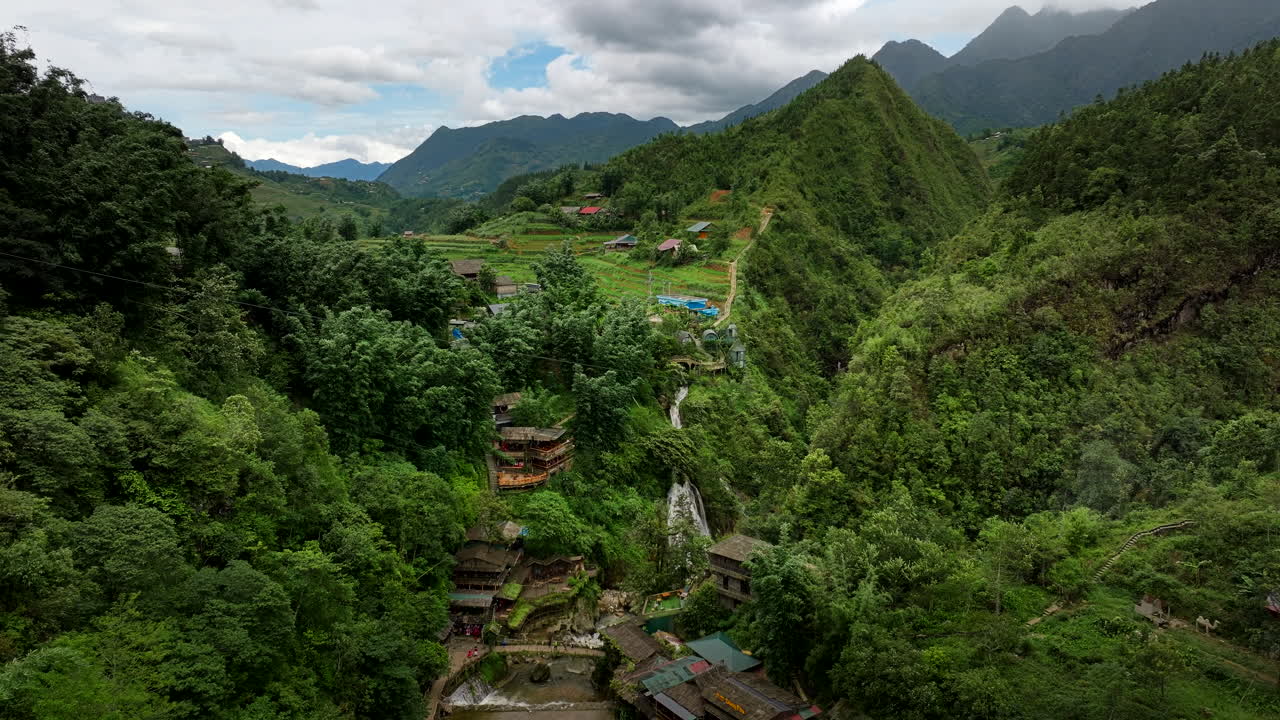 Ca Cat village valley waterfall surrounded by lush green mountains in Sapa town