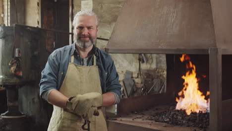 Portrait-of-Cheerful-Blacksmith-by-Forge